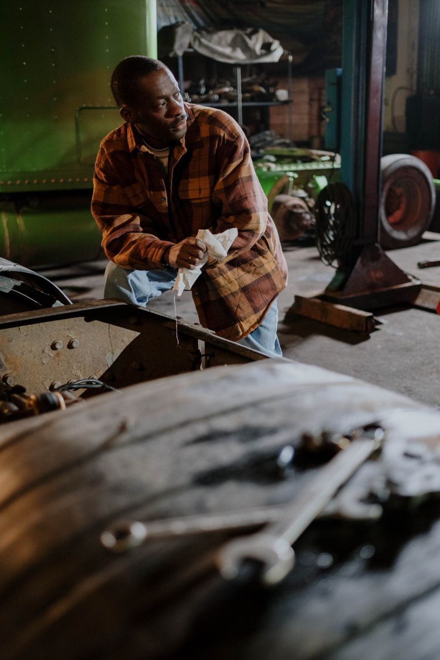 A mechanic in work clothes standing in a garage workshop